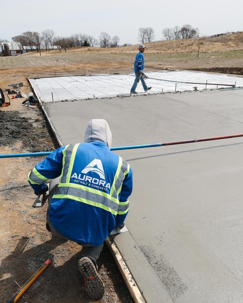 Aurora concrete driveway contractor finishing the edge of a freshly poured concrete slab.