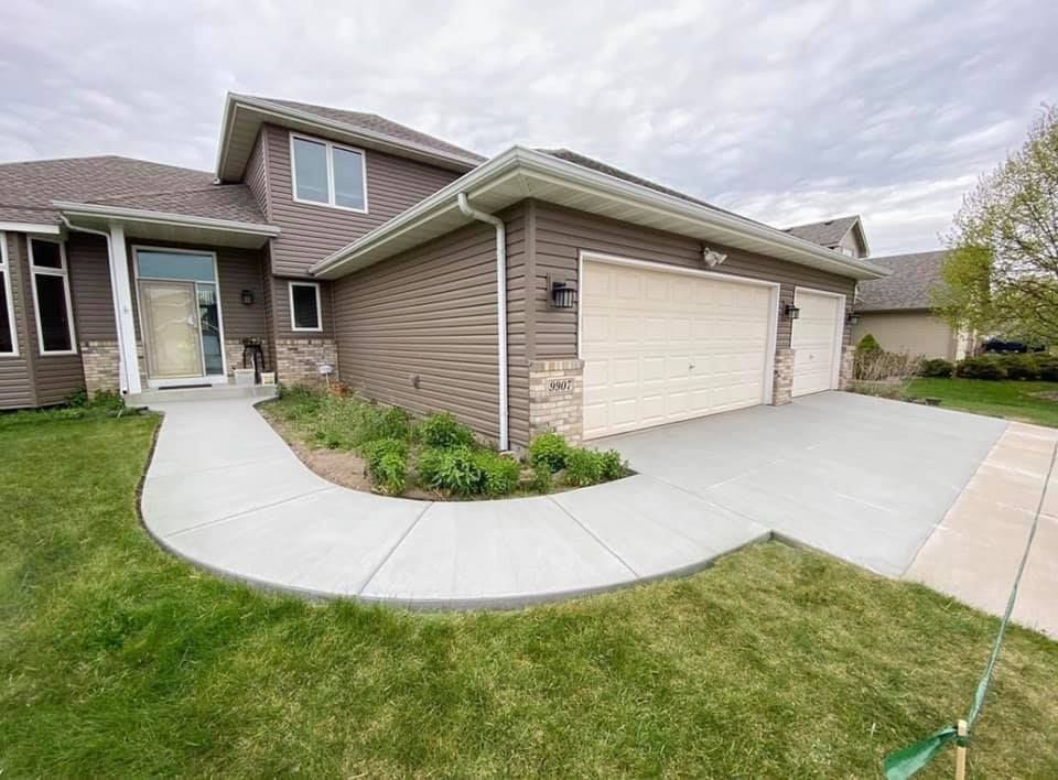 Concrete driveway installation with a matching curved sidewalk at a home in Ramsey, MN.