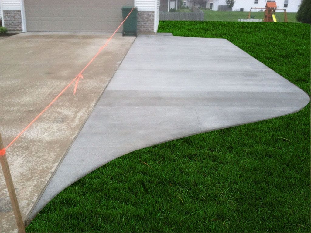 New curved concrete driveway extension poured beside an existing driveway by a driveway extension contractor.