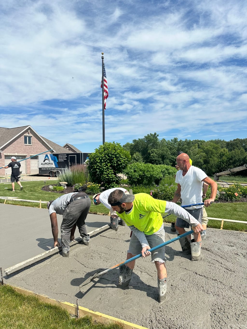 Aurora crew screeding fresh concrete for a new concrete driveway.