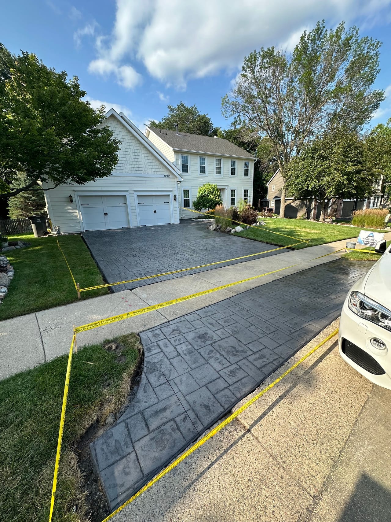 New concrete driveway with a decorative stamped finish leading to a two-car garage.